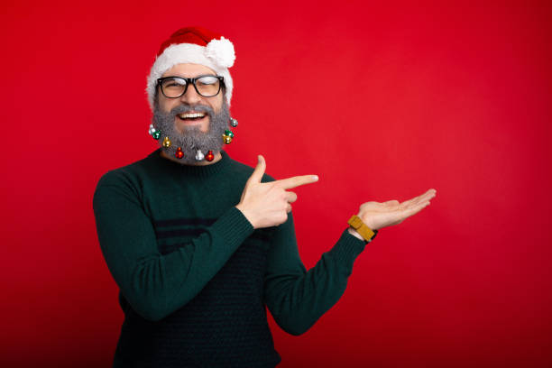 istock Cheerful man with white decorated beard pointing at palm, showing product 1189377805