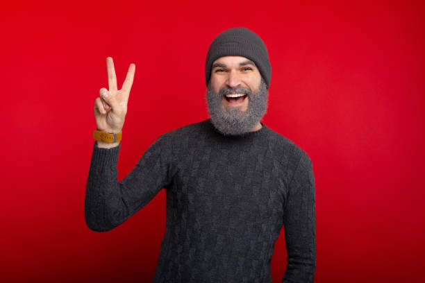 istock Cheerful young man with white beard showing PEACE gesture 1189380496
