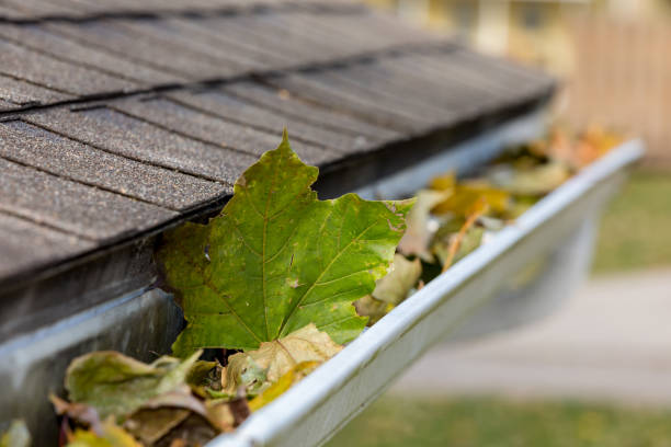 Closeup of house rain gutter clogged with colorful leaves falling from trees in fall. Concept of home maintenace and repair landscape, no people clogged stock pictures, royalty-free photos & images