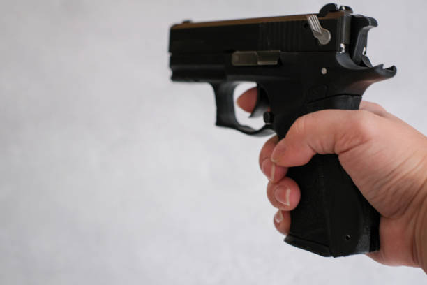 law enforcement aim pistol by the hand in academy shooting range in flare. a pistol 9mm, in the hands of women, stock photo