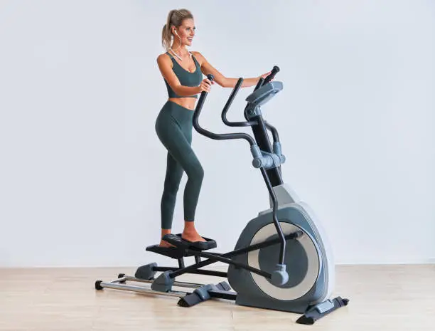 Woman exercising on x-trainer in fitness studio