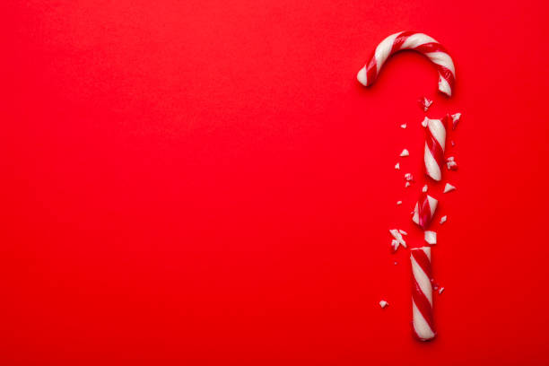 istock Broken Christmas candy cane on red background. Minimal composition with space for text 1189387504