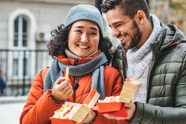 istock Young couple eating fast food and walking 1189388049