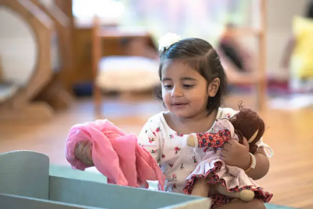 Photo of Little Girl Playing Pretend With Her Doll stock photo