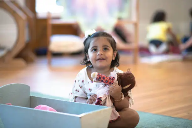 Photo of Little Girl Playing Pretend With Her Doll stock photo