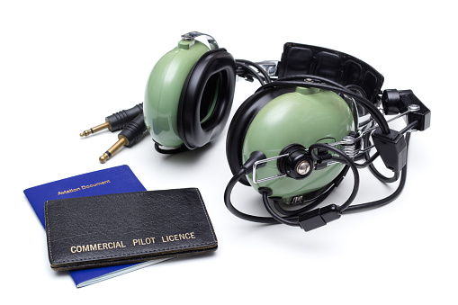 Commercial pilot license and headset on white