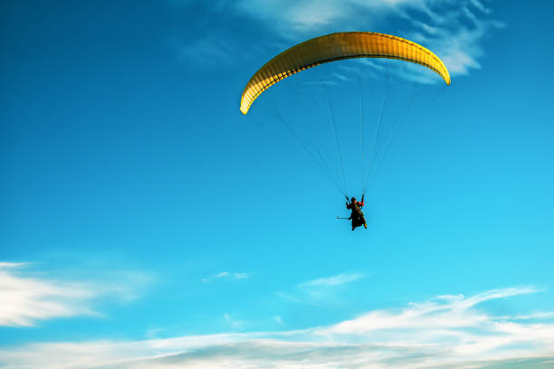istock yellow paraglider flying in the sky 1189390654
