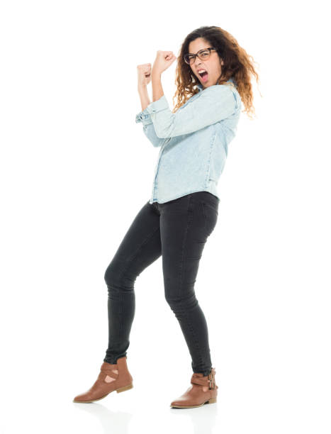 full length / one person / side view / profile view / looking at camera of 30-39 years old adult beautiful curly hair puerto rican ethnicity / latin american and hispanic ethnicity female / young women standing / cool attitude and showing fist - women standing fist success imagens e fotografias de stock