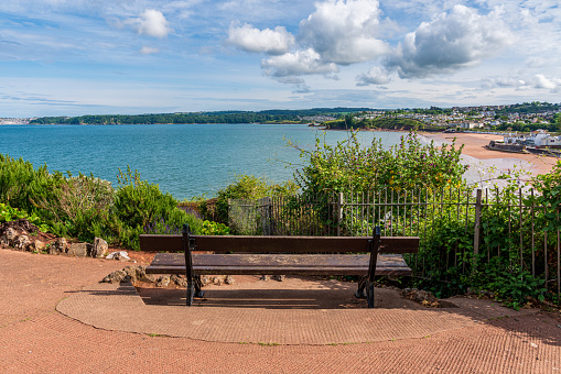 A bench with a view over the Goodrington Sands in Roundham, Torbay, England, UK