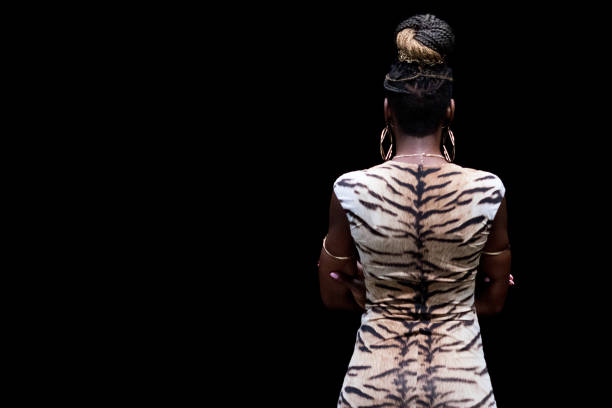 full length / rear view / back / one person of 20-29 years old adult beautiful cornrow braids / black hair / long hair african ethnicity / african-american ethnicity female / young women standing in front of black background who is confidence - one young woman only only young women one woman only 20 25 years imagens e fotografias de stock