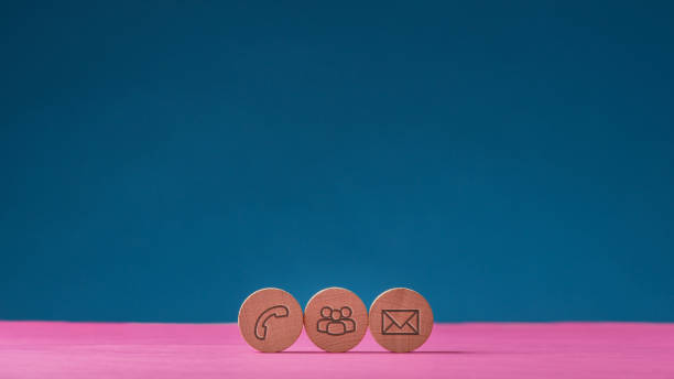 Three wooden cut circles with contact and communication icons stock photo