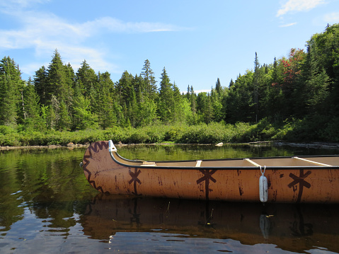 Mauricie National Park, Quebec Canada.Look out point with blue sky and tranquil waters landscape. Canadian rabaska canoe resting by the calm water in beautiful  Wapizagonke lake.