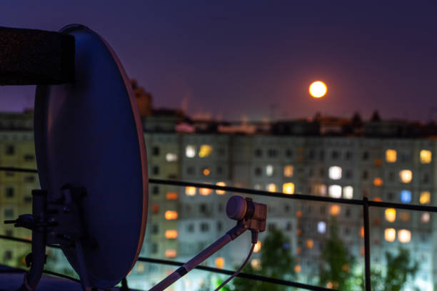 satellite dish on russian condominium roof at full moon night with selective focus and blur satellite dish on russian condominium roof at full moon night. Closeup shot with selective focus and blur. parabola stock pictures, royalty-free photos & images