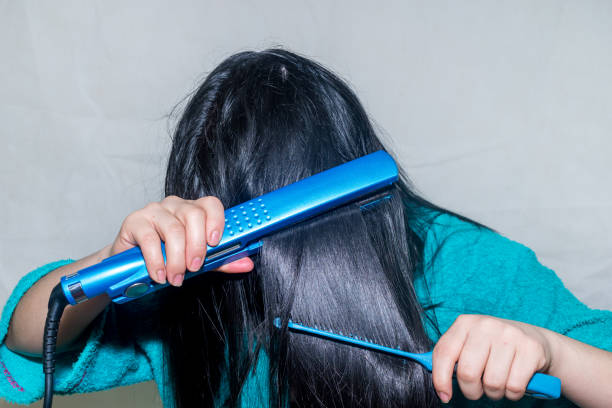 istock woman ironing her hair 1189400912