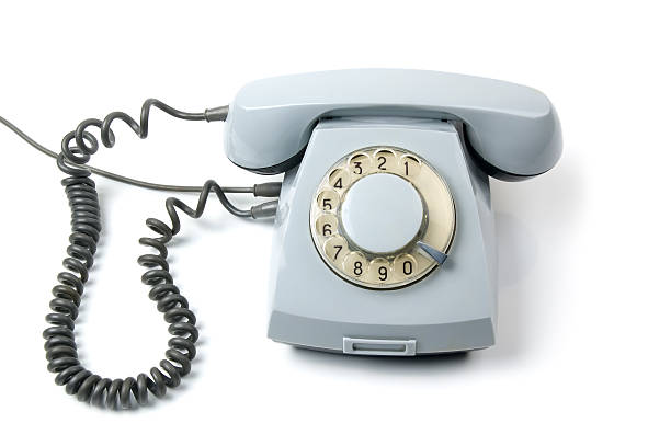Nostalgia landline rotary telephone close-up, isolated on gray background. Retro communication equipment for connection.