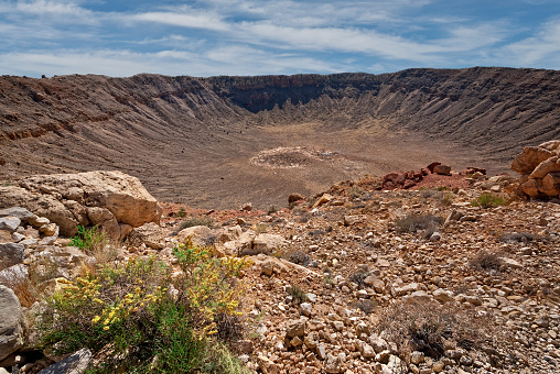 The Arizona Meteor Crater (Barringer Meteorite Crater) formed 50,000 years ago when an asteroid plunged through the Earth’s atmosphere and crashed into what is now central Arizona. This area was not populated by humans at the time. Because of Arizona’s dry climate and the crater’s relatively young age, Meteor Crater is the best preserved impact crater on Earth. The small asteroid was just 150 feet across. Traveling at around 8 miles per second the force of the impact was tremendous. In just a few seconds the crater was formed when millions of tons of rock were thrown out. Today Meteor Crater is a famous tourist attraction with a museum featuring displays about the history of the crater. Scientist from all over the world come to Meteor Crater to study it. Meteor Crater is near Winslow, Arizona, USA.