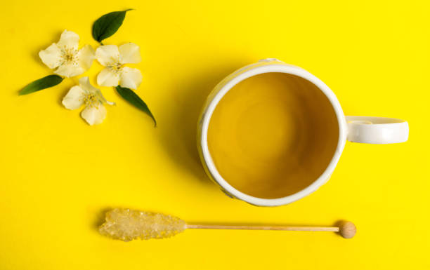 Jasmine herbal tea and brown sugar stick on yellow background