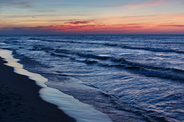 Beautiful dramatic sunset seascape with blue water and red sky.