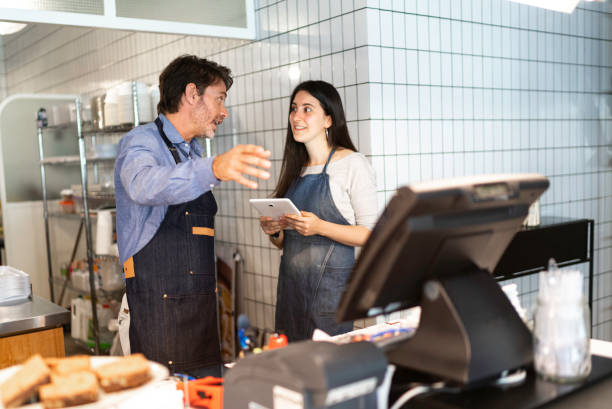istock Business owner and waiter talking at cafeteria 1189411377