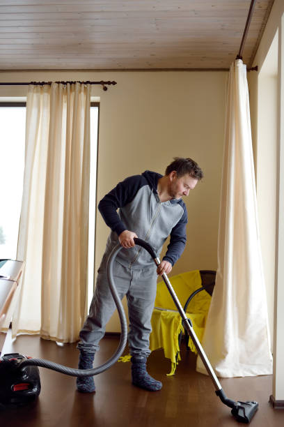 istock Man vacuuming wooden floor at home 1189417723
