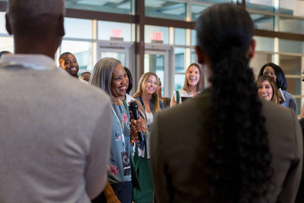 istock Smiling mature business conference speaker talks with crowd 1189420417