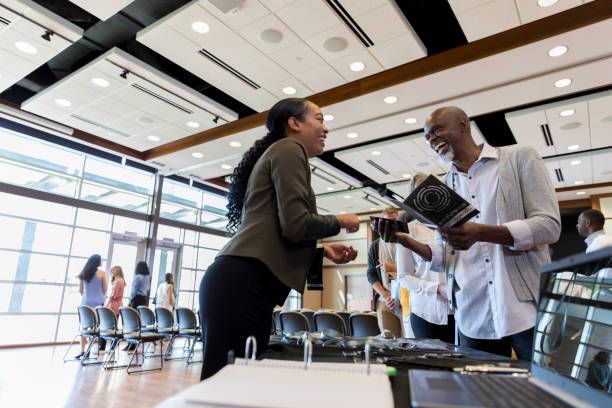 istock Confident woman helps people during business conference 1189420423