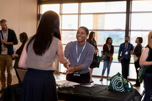 istock Smiling woman greets conference attendee 1189420957