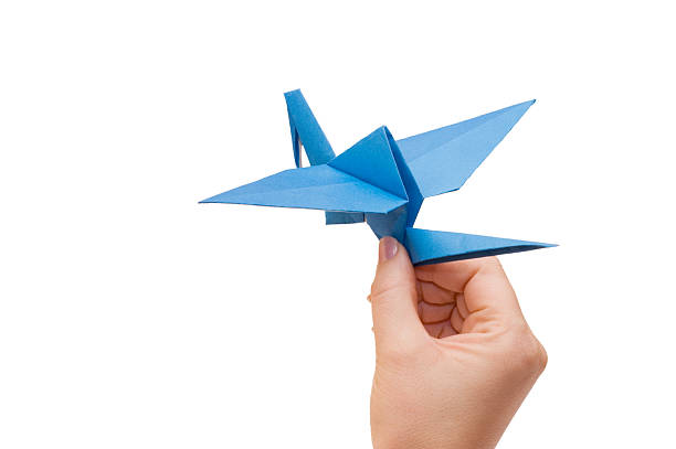 istock Origami crane in hand isolated on white background 118943046