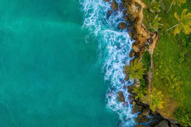 Tropical golden beach by the Caribbean ocean on the island of Jamaica. Orange sunset view from above. Tropical holidays background.