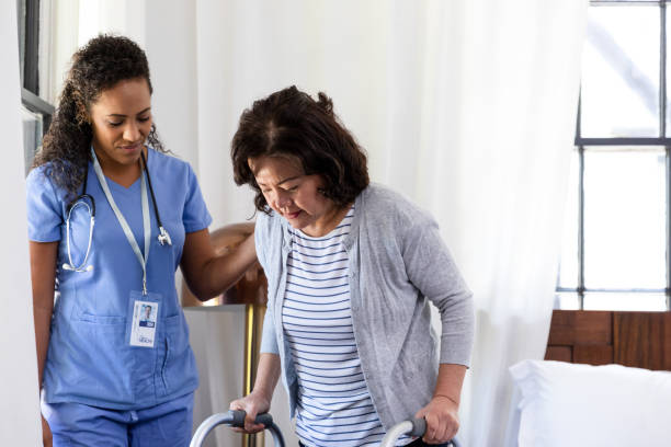 istock Widow and nurse focus intently as senior uses walker 1189436336