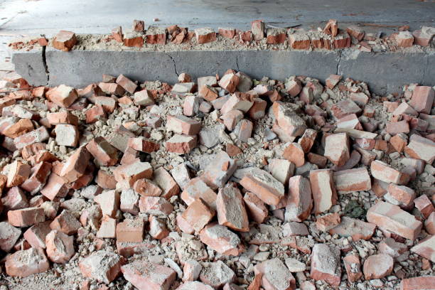 istock Pile of construction material and broken destroyed red bricks mixed with concrete at abandoned military hangar building 1189436349