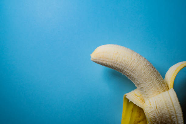 istock Half-Peeled Banana on Blue 1189438596
