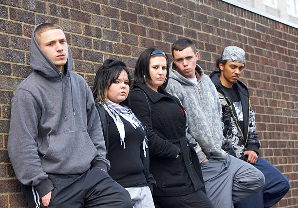 gang de jeunes s'appuyant sur le mur - gangster photos et images de collection