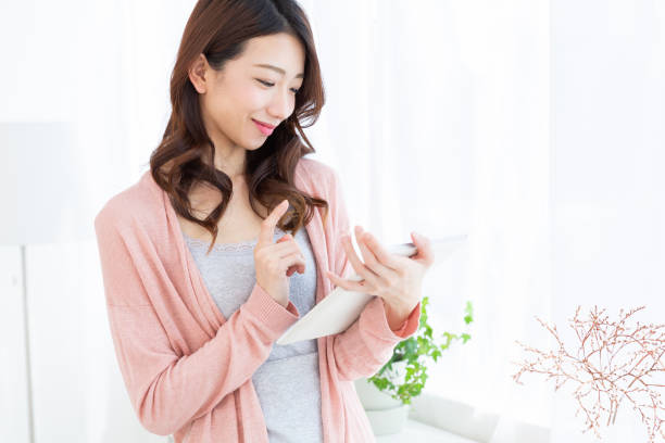 istock asian woman to see a tablet computer 1189464534