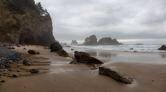 Ecola State Park, Cannon Beach, Oregon, United States. Beautiful Panoramic View of the Sandy and Rocky Beach on Pacific Ocean Coast during a cloudy summer sunrise.