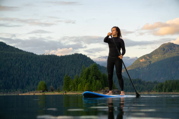 istock Adventurous Girl on a Paddle Board is paddling in a calm lake 1189471221
