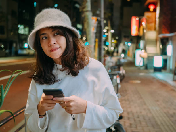 istock Woman texting outdoors in Japan. 1189471312