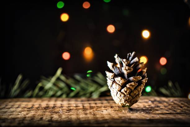 istock New Year card with pine cone and pine branches on a black background with colorful bokeh. Copy space 1189484891
