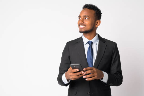 Studio shot of young handsome African businessman in suit against white background