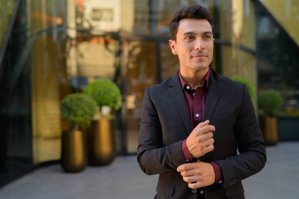 istock Young handsome Hispanic businessman thinking outside the office building 1189491268
