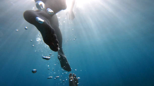 istock POV up to legs in clear blue water 1189491375