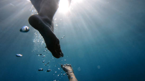 istock POV up to legs in clear blue water 1189491377