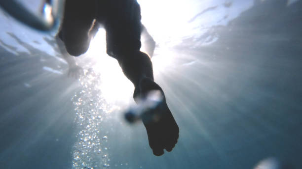 istock POV up to legs in clear blue water 1189491398
