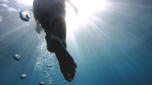 istock POV up to legs in clear blue water 1189491401