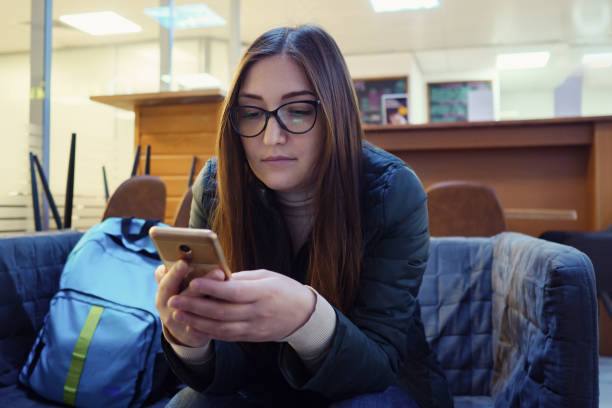 istock woman chats with friends using smartphone and smiles 1189492328