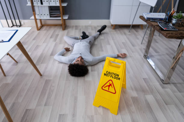 istock Man Falling On Wet Floor In Front Of Caution Sign 1189508325