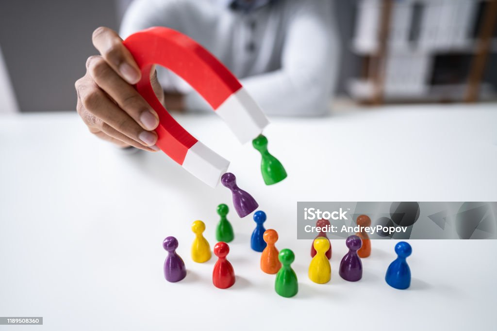 Businessperson Attracting Pawn Figures With Horseshoe Magnet Hand Holding Red Horseshoe Magnet Attracting Pawn Figures Customer Stock Photo