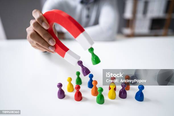 Businessperson Attracting Pawn Figures With Horseshoe Magnet Stock Photo - Download Image Now