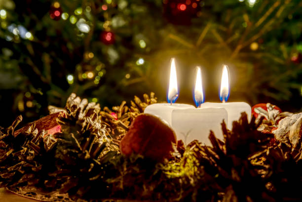 istock three burning candles with Christmas decoration from pine cones around 1189508449