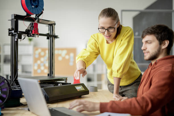 istock Young engineer pointing at laptop display during discussion of 3d printed items 1189510330